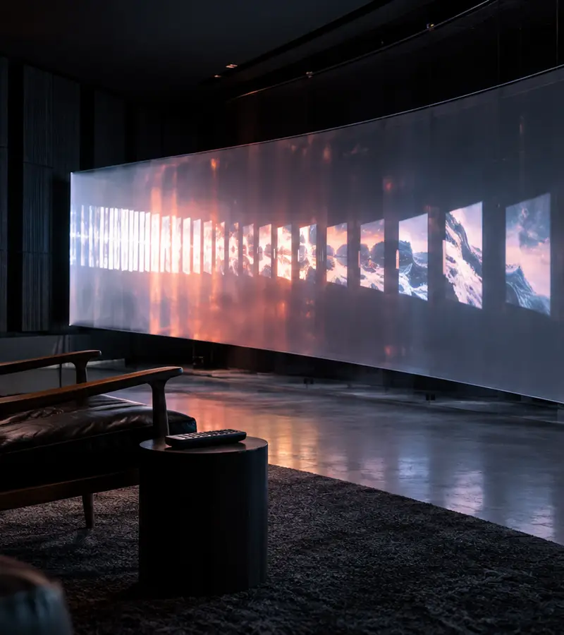 Cinematic screening room with a sequence of projected frames receding across a curved wall.